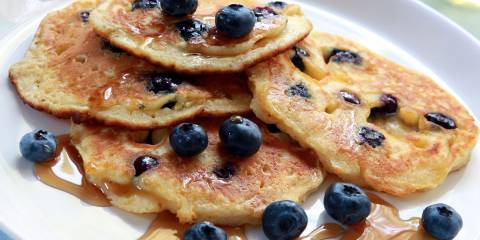 blueberry pancakes drizzled with maple syrup