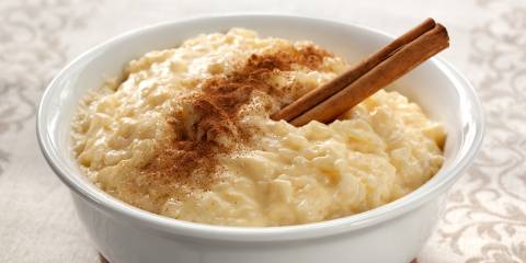 a bowl of sweetened rice pudding with cinnamon on top