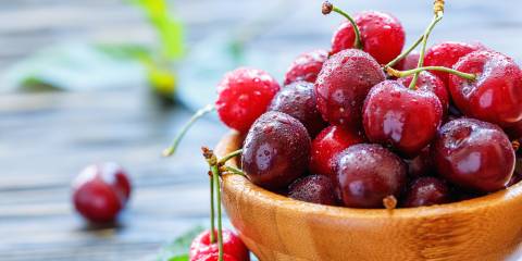 Red sweet cherries in a wooden bowl.