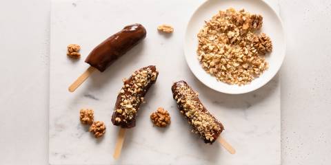 frozen banana pops rolled in chocolate with nuts on top