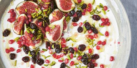 Greek Yogurt Panna Cotta with Pistachios, Pomegranate and Cranberries in a white earthen bowl. Top view.