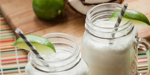 Two mug-handle mason jars full of coconut-lime cooler