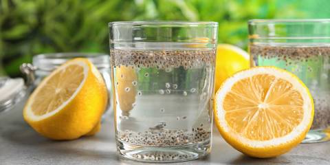 chia soaking in a glass of water with sliced lemons