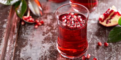 a glass of sparkling pomegranate drink on ice