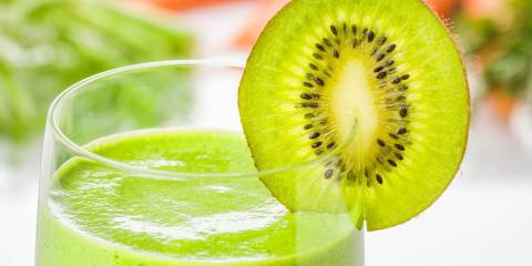 Green smoothie in glass with kiwi slice
