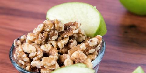 A bowl of chopped walnuts and green apple slices
