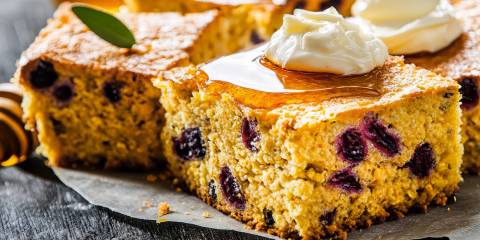 a plate of cornbread with cranberries and fresh whipped butter