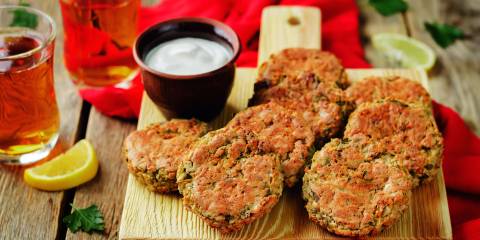 lentil and zucchini patties with a lemon and a cup of yogurt sauce
