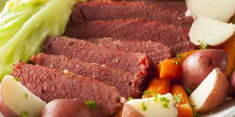 a plate of corned beef and cabbage with carrots and potatoes