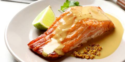 a salmon filet on a plate with mustard