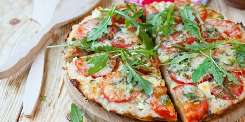 Small homemade pizza on a wooden plate