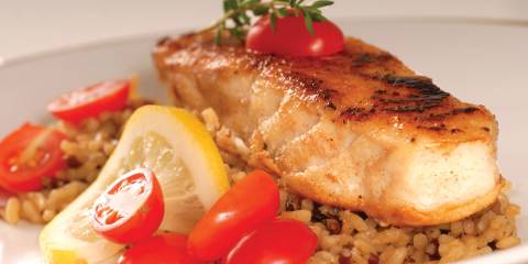 white fish filet over rice with citrus and tomatoes