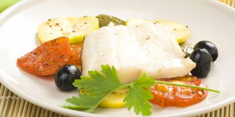 Fillet of cod baked tomatoes and black olives.