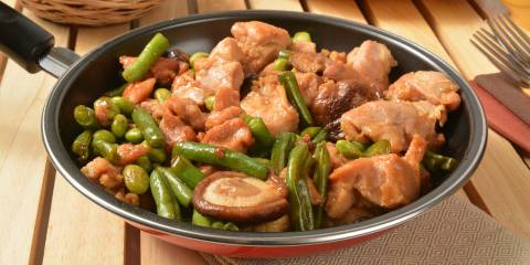 a skillet full of chicken, green beans, and shiitake mushrooms