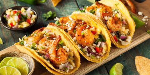 a serving board with loaded shrimp tacos