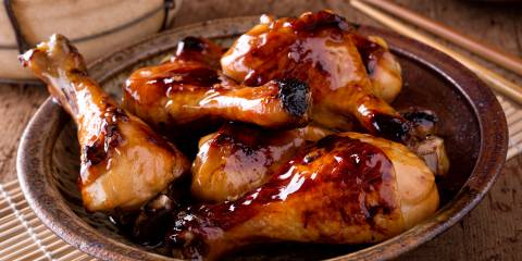 Sticky chicken on a plate ready sprinkle with scallions and serve.