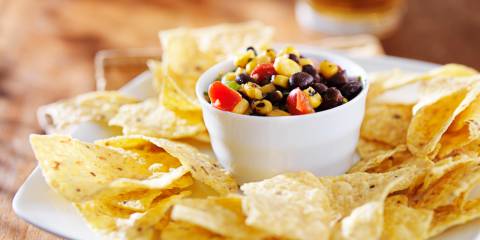 Plate of tortilla chips with a bowl of salsa in the middle. 