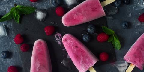Goat milk yogurt pops, surrounded by berries and ice