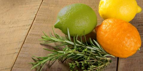 a lemon, a lime, an orange, and a sprig of rosemary