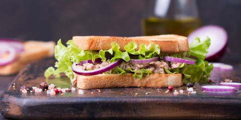 a tuna salad sandwich with red onion and lettuce