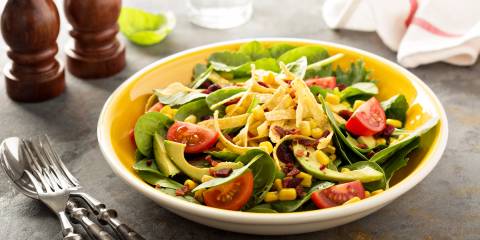 a bowl of mexican-inspired salad with corn and avocado