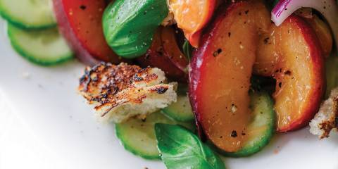 A close up image of Peach Panzanella on a white plate.