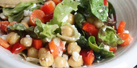 a tossed salad with greens and beans