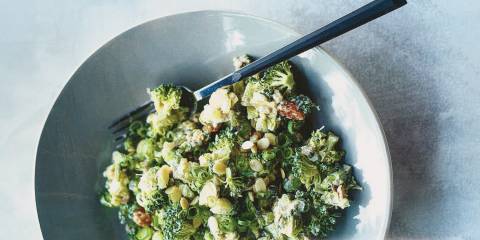 Raw Broccoli Salad in a light blue ceramic bowl on a light gray blue background.