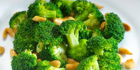 a bowl of broccoli and chopped nuts