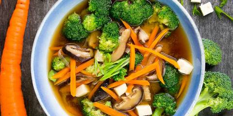 Bowl of miso soup with broccoli, carrots, and shiitake mushrooms 