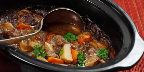 A pot full of hearty beef stew with carrots and potatoes.