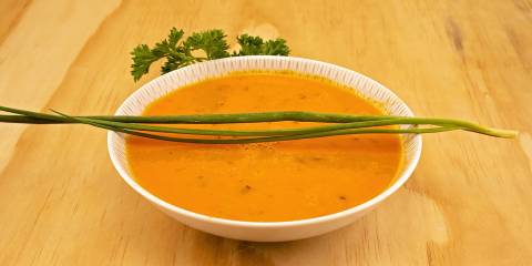 a bowl of tomato soup with fresh chives