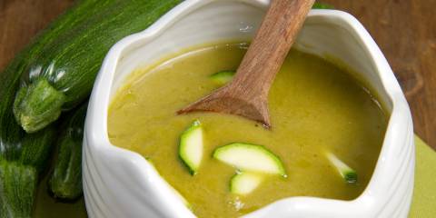 a bowl of creamy soup with sliced zucchini
