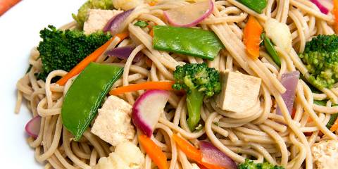 a plate of soba noodles with vegetables and tofu