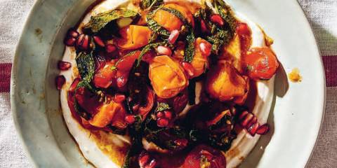 a plate of grilled tomatoes on a bed of yogurt