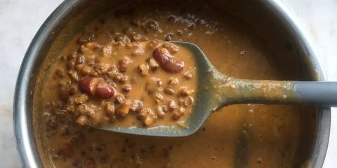 stirring a pot of fresh dal with ghee