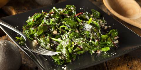 A plate of prepared leafy greens in garlic.