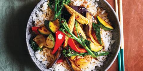 a bowl of stir-fried teriyaki vegetables on a bed of rice
