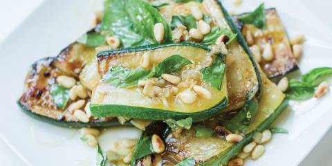 A plate of grilled zucchini, with pine nuts, honey, and basil