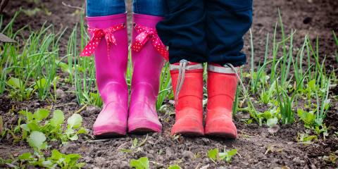 View of rubber boots, woman and child in a garden