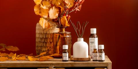 wooden dresser with vase full of fall branches, essential oils and reed diffuser