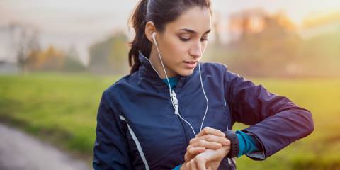a woman walking the park, checking her smartwatch
