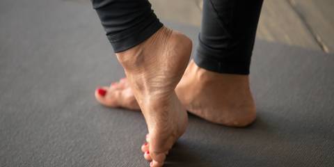 A woman doing stretches to strengthen muscles in the foot and ankle.