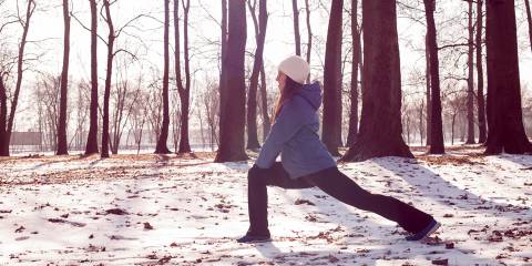 a woman stretching in the park in winter