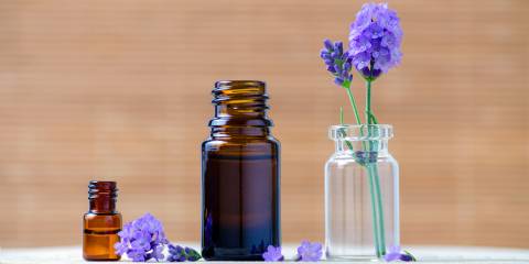 Lavender essential oil bottles and fresh flowers for aromatherapy.