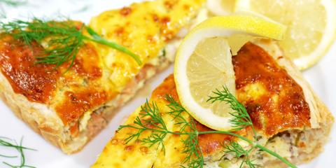 two slices of quiche, toped with sprigs of dill and a lemon wedge