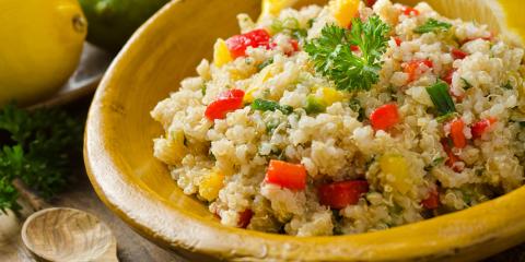 Bowl of quinoa salad with corn and chopped red pepper.