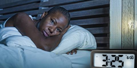Woman awake in bed sleepless suffering insomnia and anxiety