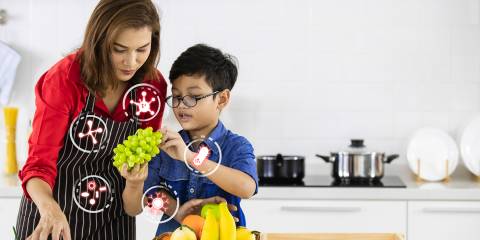 A mother and son in the kitchen choosing probiotic fruits