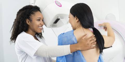 a helpful nurse getting a woman ready for her mammogram